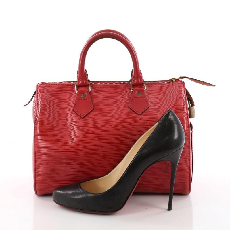 This Louis Vuitton Speedy Handbag Epi Leather 25, crafted in red epi leather, features dual rolled handles, exterior side slip pocket and gold-tone hardware. Its top zip closure opens to a red law leather interior with slip pocket. Authenticity code