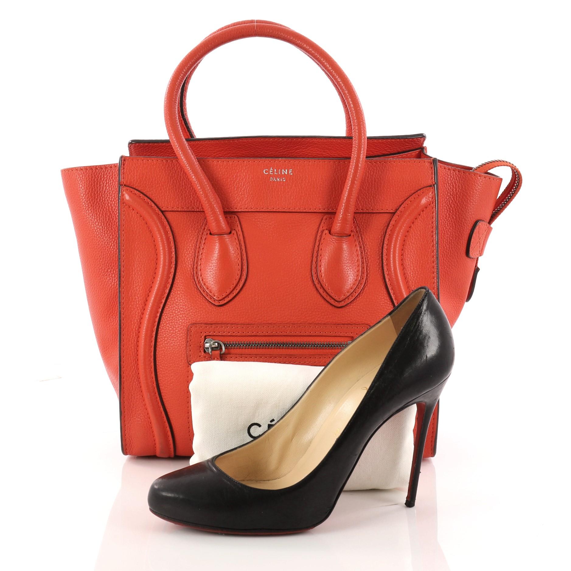 This authentic Celine Luggage Handbag Grainy Leather Micro is one of the most sought-after bags beloved by fashionistas. Crafted from red-orange grainy leather, this minimalist tote features dual-rolled handles, an exterior front pocket, stamped
