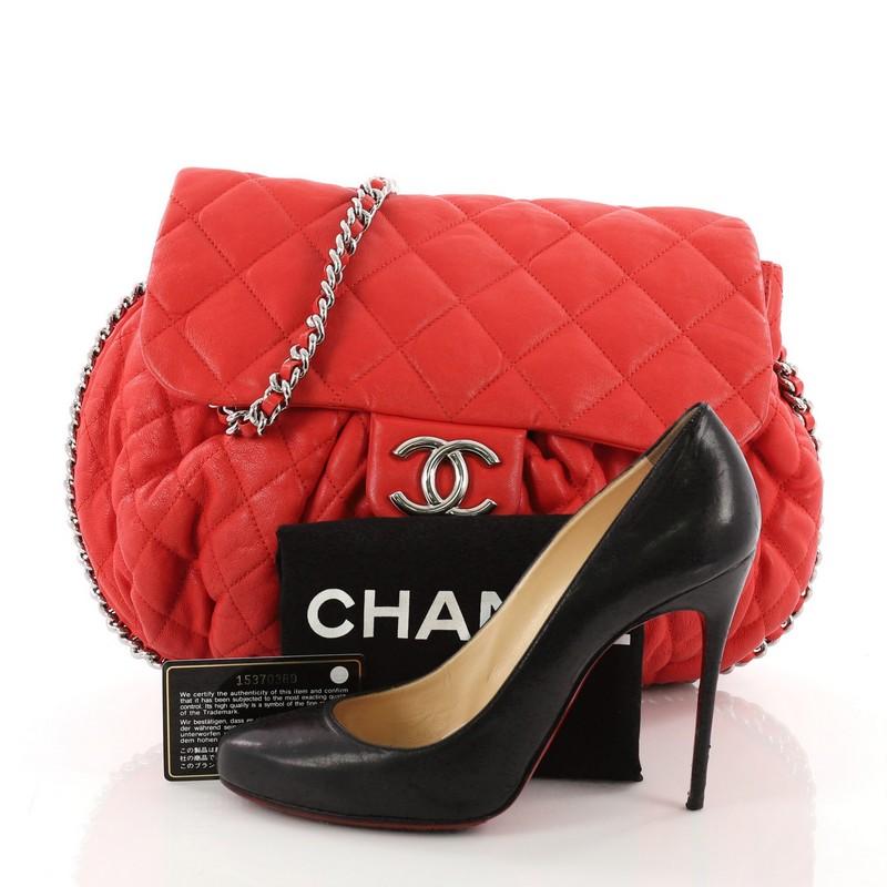 This Chanel Chain Around Flap Bag Quilted Leather Large, cafted in red quilted leather, features woven-in leather chain strap, chain-around design, frontal flap with CC logo, and silver-tone hardware accents. Its magnetic snap closure opens to a