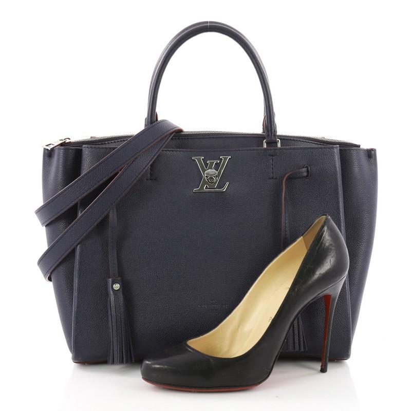 This Louis Vuitton Lockmeto Handbag Leather, crafted from blue leather, features dual rolled leather top handles, two side compartments, and silver-tone hardware accents. Its center zip closure opens to a red microfiber-lined interior with slip