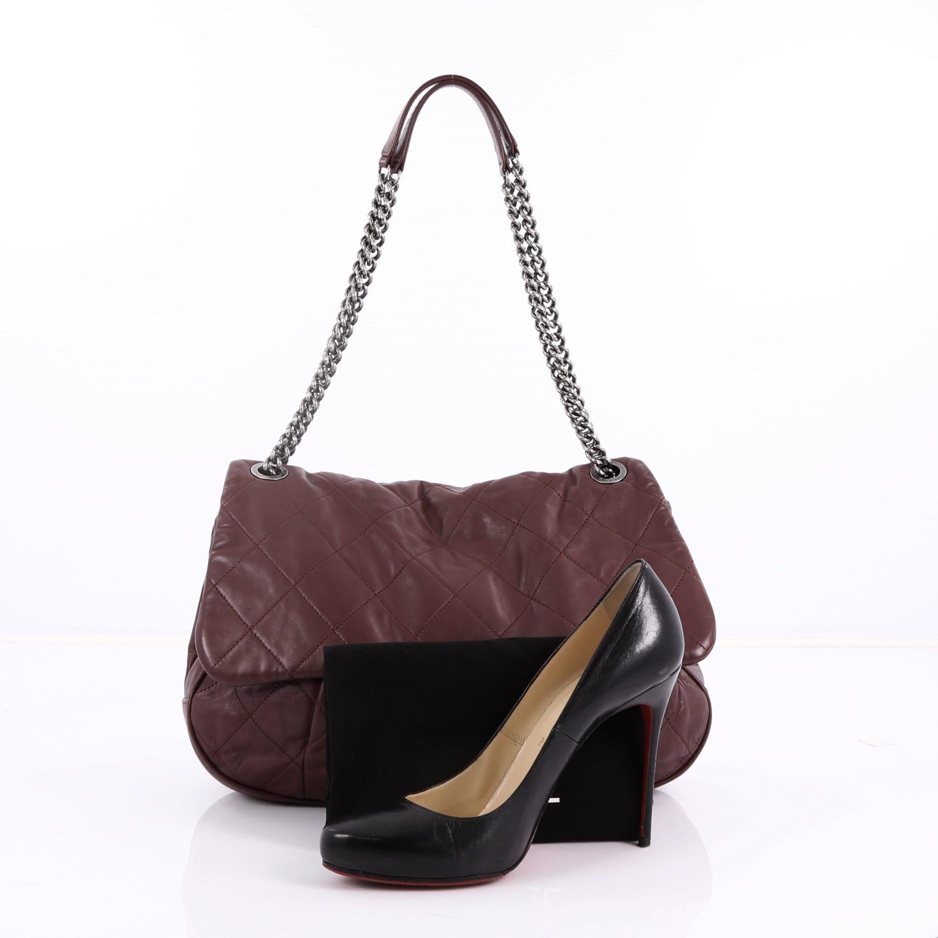 This Chanel Coco Pleats Flap Bag Quilted Calfskin, crafted in burgundy quilted calfskin leather, features dual chain link strap with leather pads, frontal flap, and aged-silver hardware. Its CC turn lock closure opens to a gray fabric interior