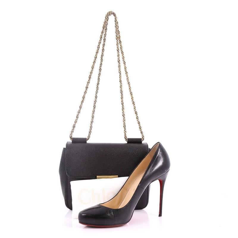 This Chloe Elsie Chain Shoulder Bag Leather Small, crafted in black leather, features twisted chain straps, rotating floral closure and gold-tone hardware. It opens to a beige leather interior with slip pocket. **Note: Shoe photographed is used as a