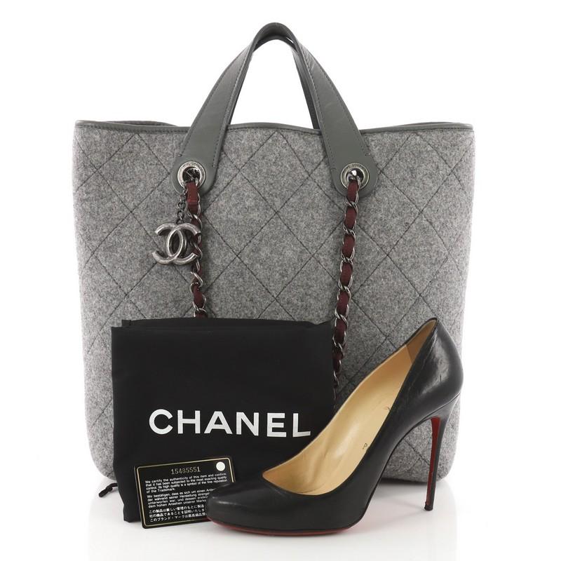 This Chanel Pop Tote Quilted Felt Large, crafted from grey quilted felt, features dual flat handles, woven-in fabric chain straps, and aged silver-tone hardware accents. It opens to a grey quilted felt interior. Hologram sticker reads: 15485551.
