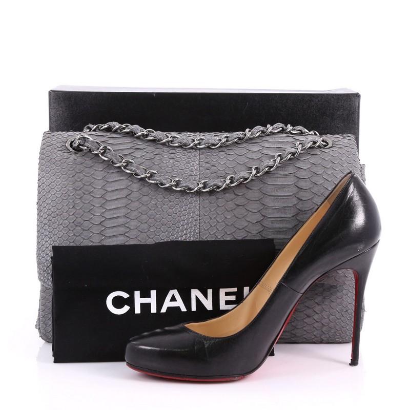 This Chanel Classic Double Flap Bag Matte Python Jumbo, crafted in genuine gray python skin, features woven in python chain strap, back slip pocket and silver-tone hardware. Its CC turn lock closure opens to a gray leather interior with slip pocket.
