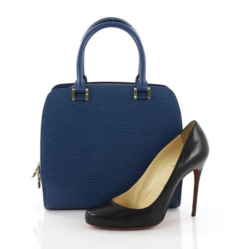 This Louis Vuitton Pont Neuf Handbag Epi Leather PM, crafted from blue epi leather, features dual rolled leather handles, slip compartments at the front and back, and gold-tone hardware accents. Its zip-around closure opens to a blue