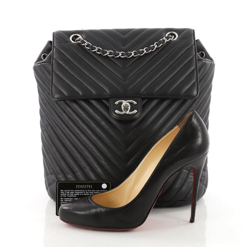 This Chanel Urban Spirit Backpack Chevron Calfskin Large, crafted in black chevron quilted calfskin, features adjustable leather shoulder straps, exterior back pocket, and silver-tone hardware. Its cinch cord opening and CC turn-lock closure opens