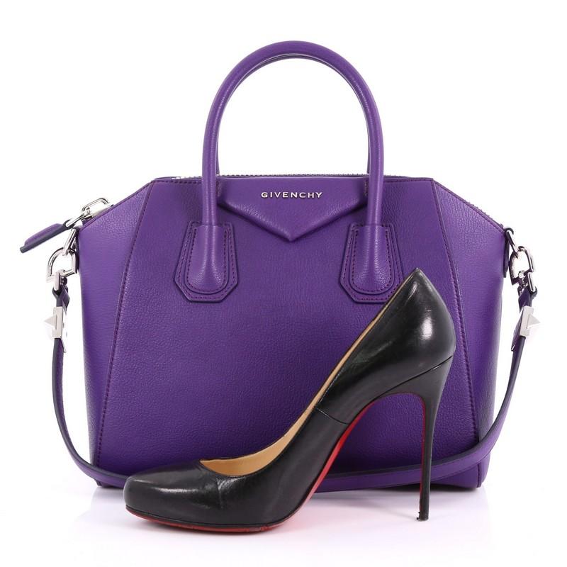 This Givenchy Antigona Bag Leather Medium, crafted from purple leather, features dual rolled leather handles and silver-tone hardware. Its zip closure opens to a brown fabric interior with zip and slip pockets. **Note: Shoe photographed is used as a