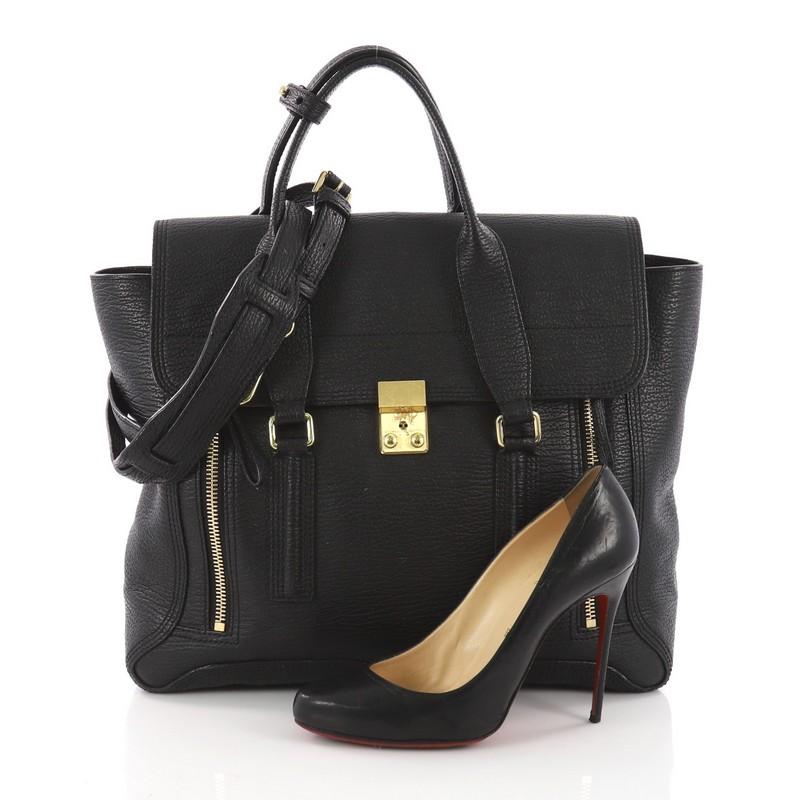 This 3.1 Phillip Lim Pashli Satchel Leather Large, crafted from black leather, features dual top handles, expandable zip sides, top flap push-lock closure and gold-tone hardware accents. Its push-lock closure opens to a black fabric interior with a