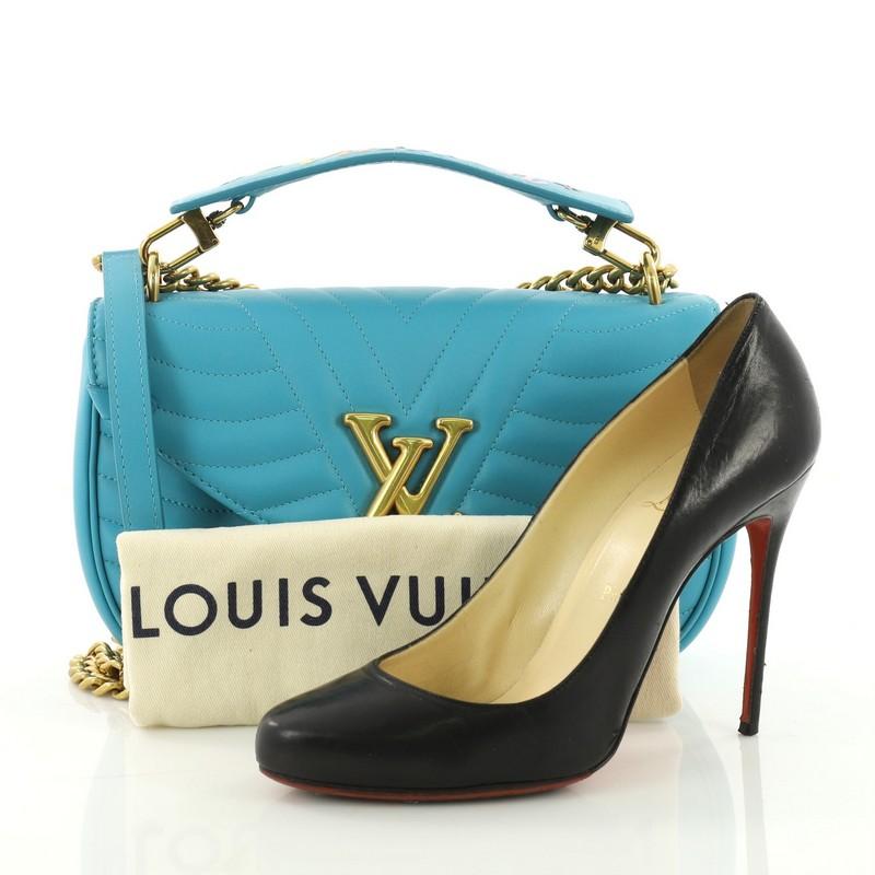 This Louis Vuitton New Wave Chain Bag Quilted Leather MM, crafted from blue quilted leather, features a sliding chain-link shoulder strap with leather pad, detachable handle signed “Louis Vuitton,” and bronze-tone hardware. It opens to a blue