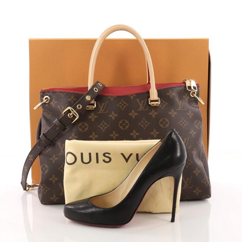 This Louis Vuitton Pallas Tote Monogram Canvas, crafted from brown monogram coated canvas with red calfskin trims, features dual rolled handles, protective base studs and gold-tone hardware. Its top two-way zip closure opens to a red