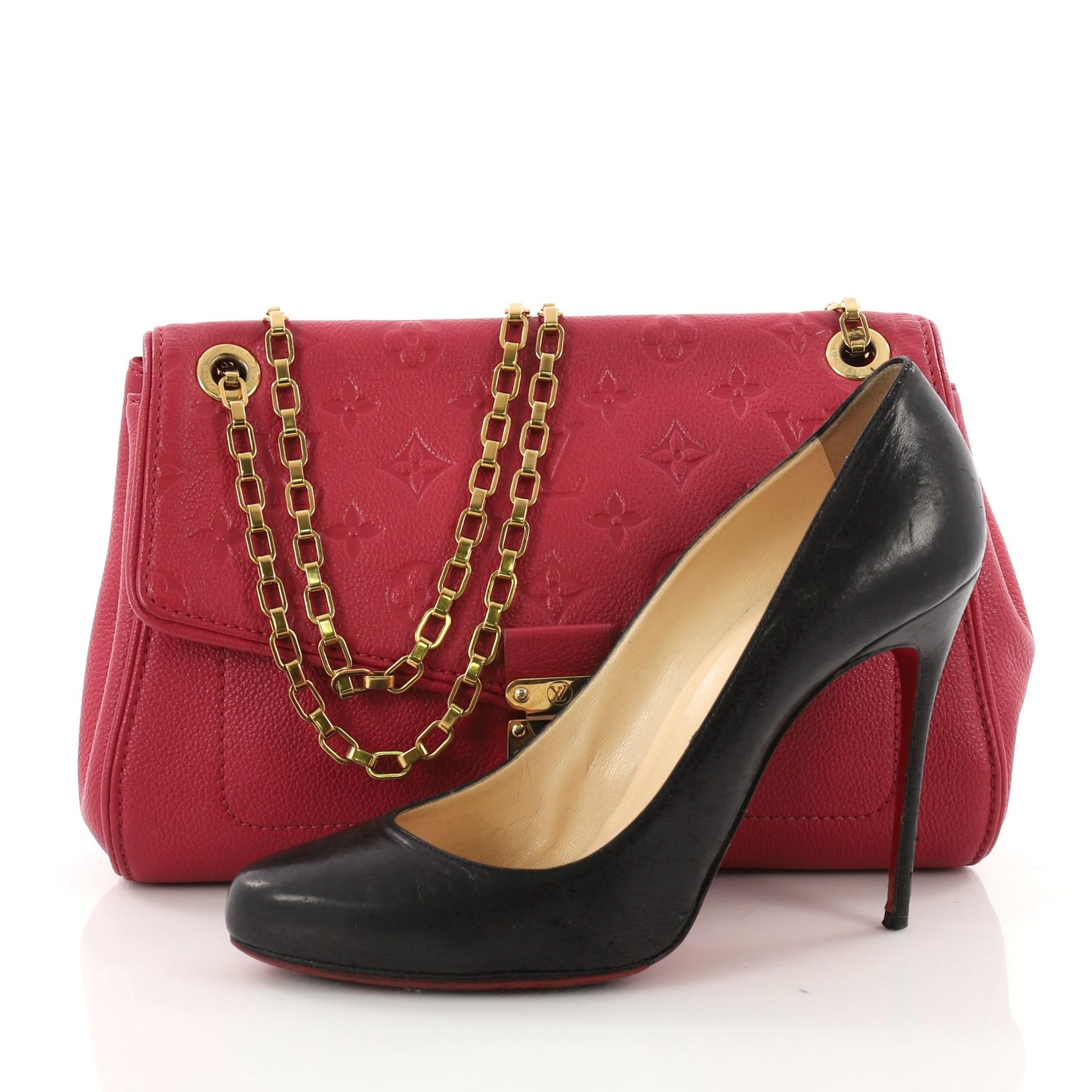 This Louis Vuitton Saint Germain Handbag Monogram Empreinte Leather PM, crafted from pink monogram empreinte leather, features gold chain-link shoulder strap and gold-tone hardware accents. Its S-lock closure opens to a red microfiber interior with