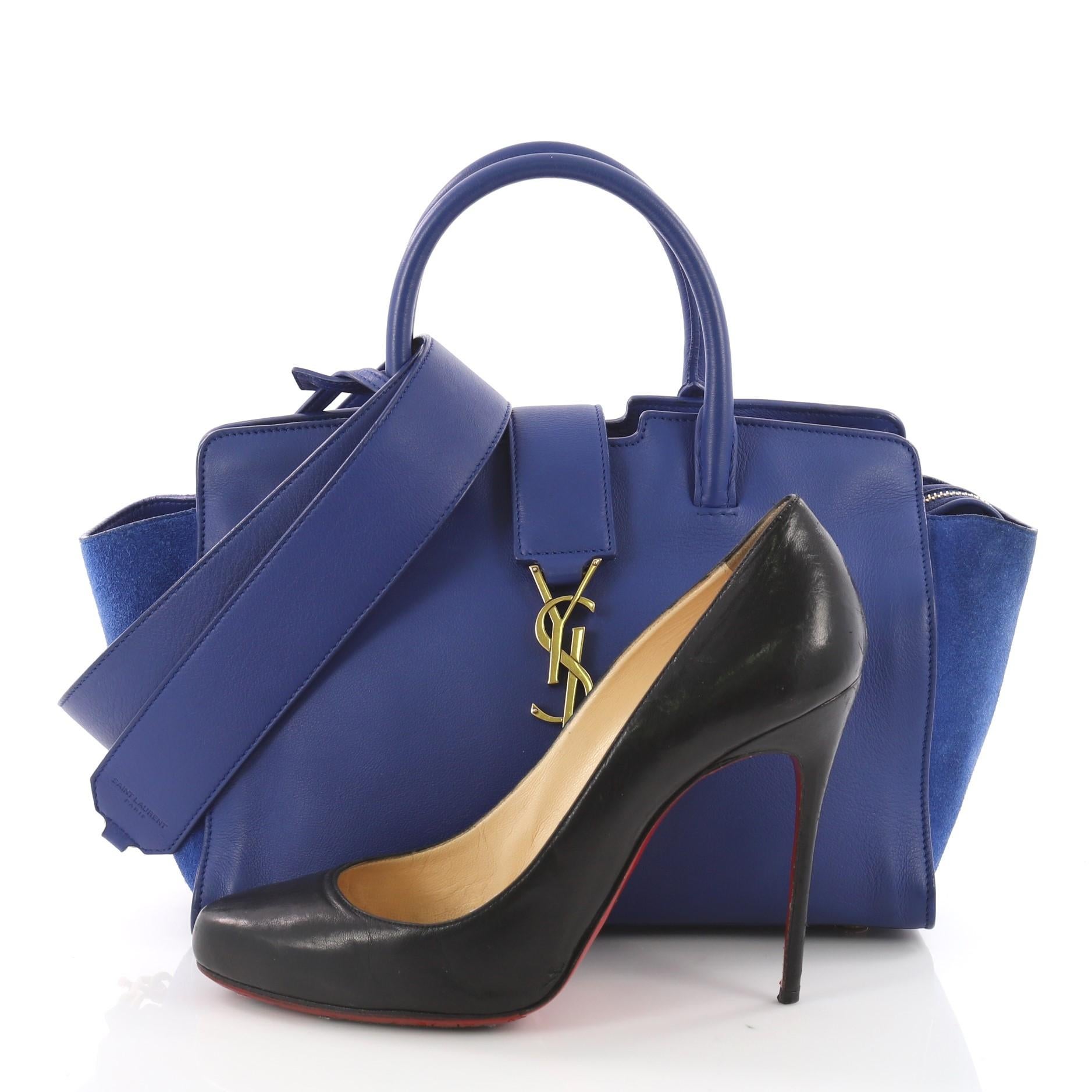 This Saint Laurent Monogram Cabas Downtown Leather with Suede Baby, crafted from blue leather, features dual rolled handles, YSL metal logo at the front, and gold-tone hardware . Its magnetic snap and zip closure opens to a blue suede interior with