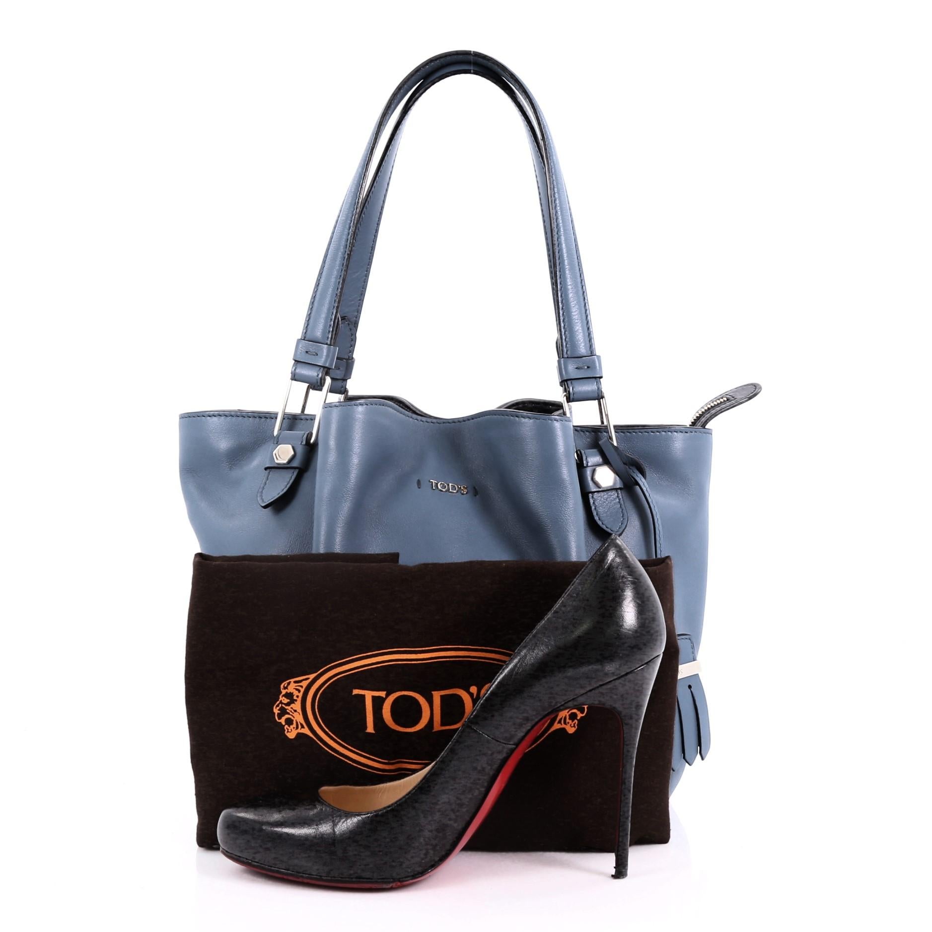 This Tod's Flower Bag Leather Medium, crafted from blue leather, features dual flat leather handles, hexagonal stud detailing and silver-tone hardware. Its top zip closure opens to a navy blue fabric interior with zip and slip pockets **Note: Shoe