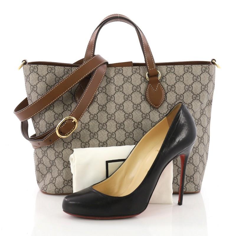 This Gucci Convertible Soft Tote GG Coated Canvas Small, crafted in brown GG coated canvas, features dual leather handles, and gold-tone hardware. Its hidden magnetic snap closure opens to a blush microfiber interior with zip and slip pockets.