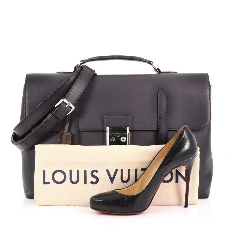 This Louis Vuitton Cartable Briefcase Ombre Leather, crafted from black ombre leather, features a leather handle, front flap with belt and buckle closure. Its press-lock closure opens to a black microfiber interior with a zip compartment and slip