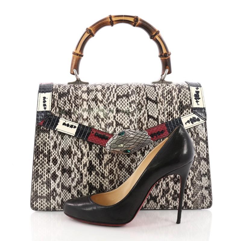 This Gucci Lilith Top Handle Bag Snakeskin Medium, crafted in genuine taupe snakeskin, features bamboo top handle, printed genuine snakeskin detail along the flap, Kingsnake closure, and aged-silver-tone hardware. Its push lock closure opens to a