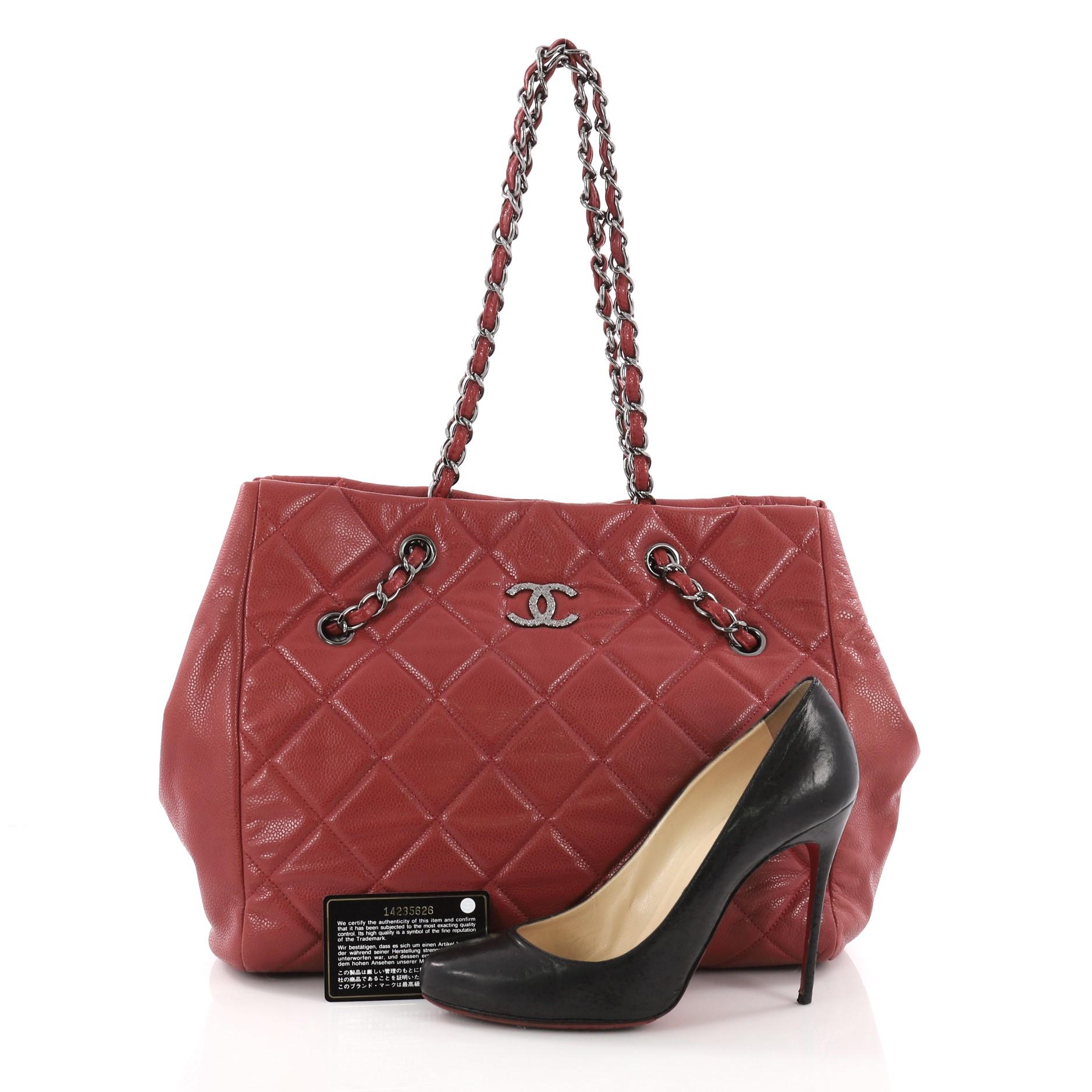 This Chanel Cells Tote Quilted Caviar Large, crafted in red quilted caviar leather, features woven-in leather chain strap, protective base studs and gunmetal-tone hardware. Its accordion style open top showcases a beige fabric interior with zip and
