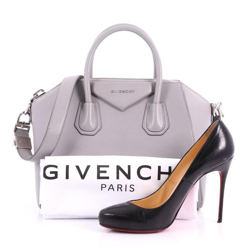 This Givenchy Antigona Bag Leather Small, crafted from grey leather, features dual rolled leather handles and silver-tone hardware. Its zip closure opens to a black fabric interior with zip and slip pockets. **Note: Shoe photographed is used as a