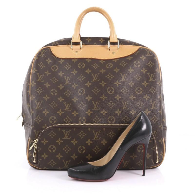 This Louis Vuitton Evasion Travel Bag Monogram Canvas MM, crafted in brown monogram coated canvas, features dual-rolled leather handles, exterior front zip bottom compartment and gold-tone hardware. Its two-way zip closure opens to a beige fabric
