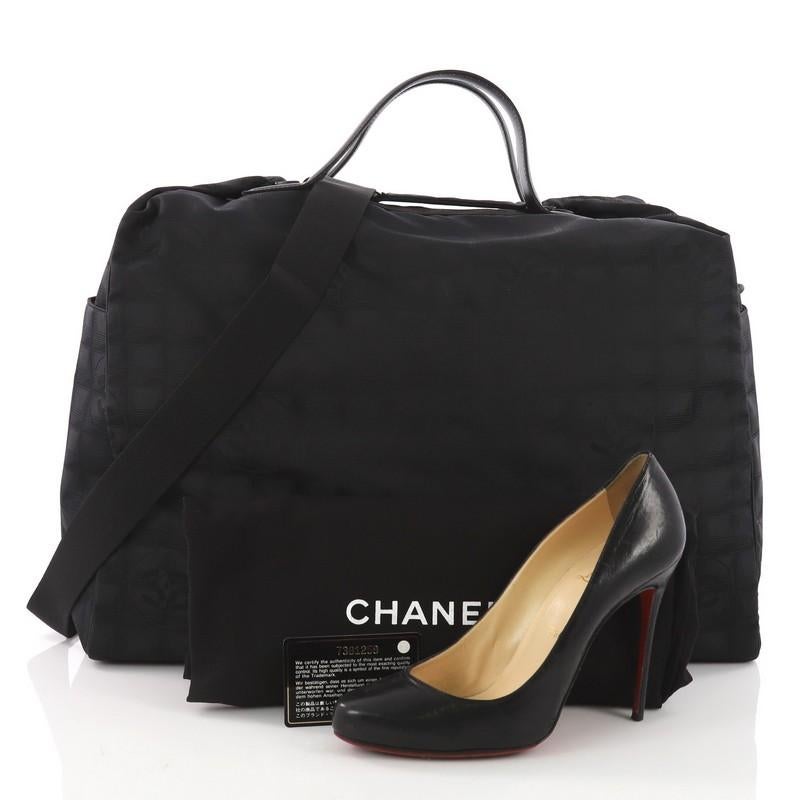 This Chanel Travel Line Duffle Bag Nylon Large, crafted from black nylon, features dual flat handles, and black-tone hardware. Its zip closure opens to a black nylon interior. Hologram sticker reads: 7381259. **Note: Shoe photographed is used as a