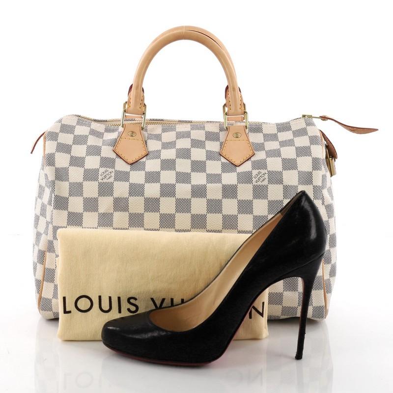 This Louis Vuitton Speedy Handbag Damier 30, crafted in damier azur coated canvas, features dual-rolled handles, vachetta leather trims and gold-tone hardware. Its top zip closure opens to a beige fabric interior with slip pocket. Authenticity code