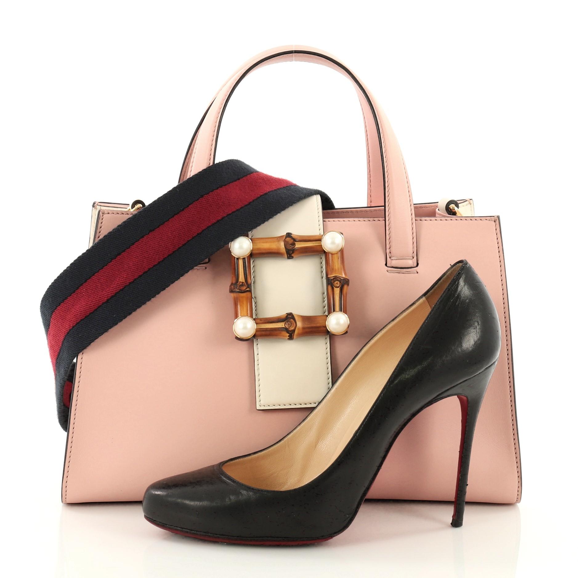 This Gucci Bamboo Buckle Tote Leather Small, crafted in pink leather, features dual leather handles, bamboo buckle closure and gold-tone hardware. Its bamboo buckle closure opens to a gray microfiber interior with zip and slip pockets. **Note: Shoe