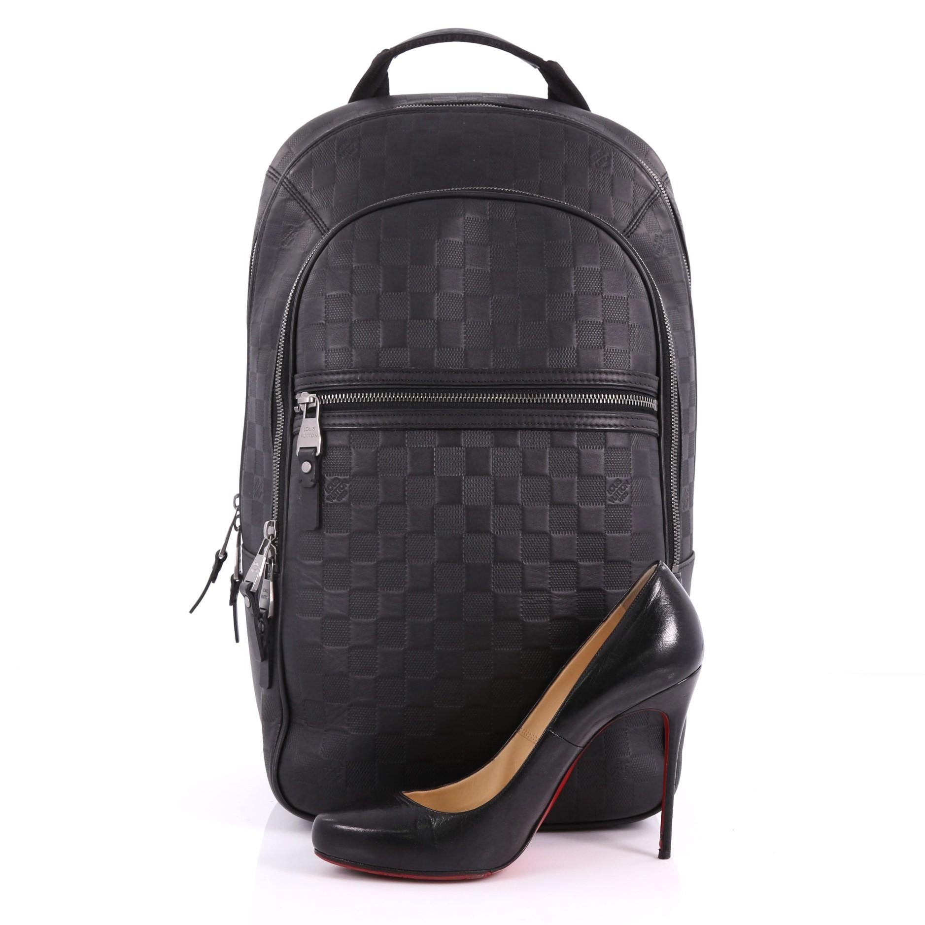 This Louis Vuitton Michael NM Backpack Damier Infini Leather, crafted in black damier infini leather, features a short flat leather top handle, canvas padded backpack straps, two exterior front zip pockets, matte silver-tone hardware. Its two-way