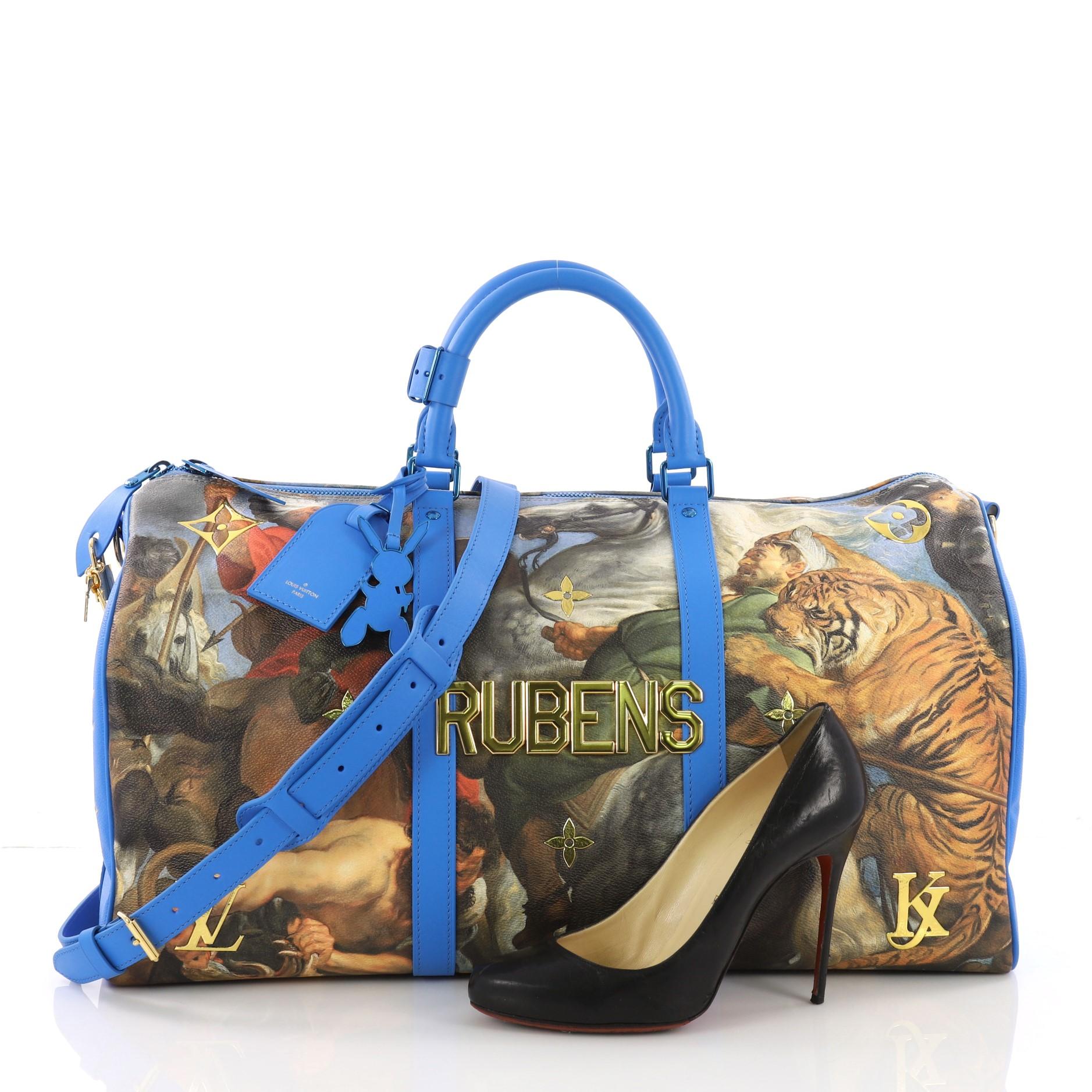 This Louis Vuitton Keepall Bandouliere Bag Limited Edition Jeff Koons Rubens Print Canvas 50, crafted from blue printed coated canvas, features dual rolled handles, gold monogram and flower applique, reflective 'Rubens' metallic letters, and