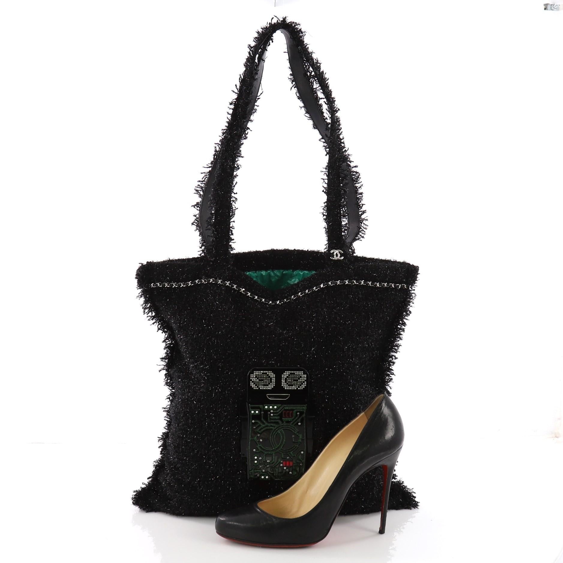 This Chanel Shopping Tote Embellished Tweed Large, crafted in black embellished tweed, features dual leather and tweed handles, ruffled trim throughout, plexiglass crystal embellishment, leather threaded top trim and silver-tone hardware. Its wide