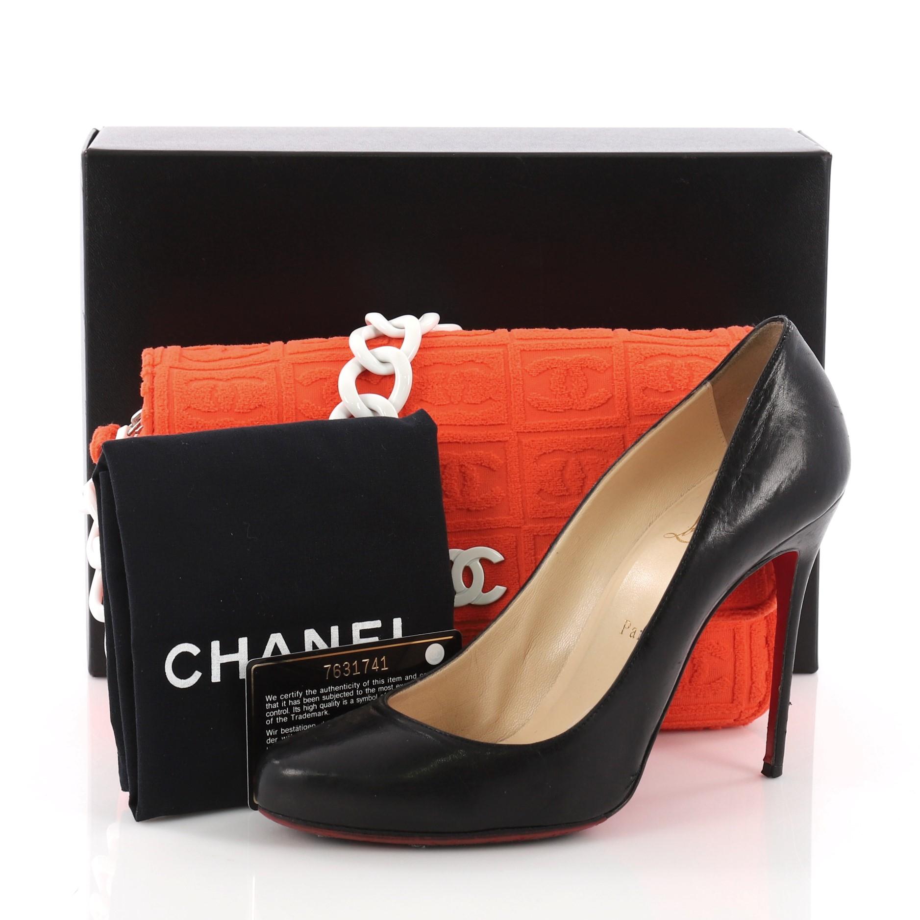 This Chanel Sport Line Resin Camera Flap Bag Terry Cloth Medium, crafted in orange quilted terry cloth, features frontal flap with white resin CC logo, resin chain strap and silver-tone hardware. Its magnetic and zip closure opens to a white leather