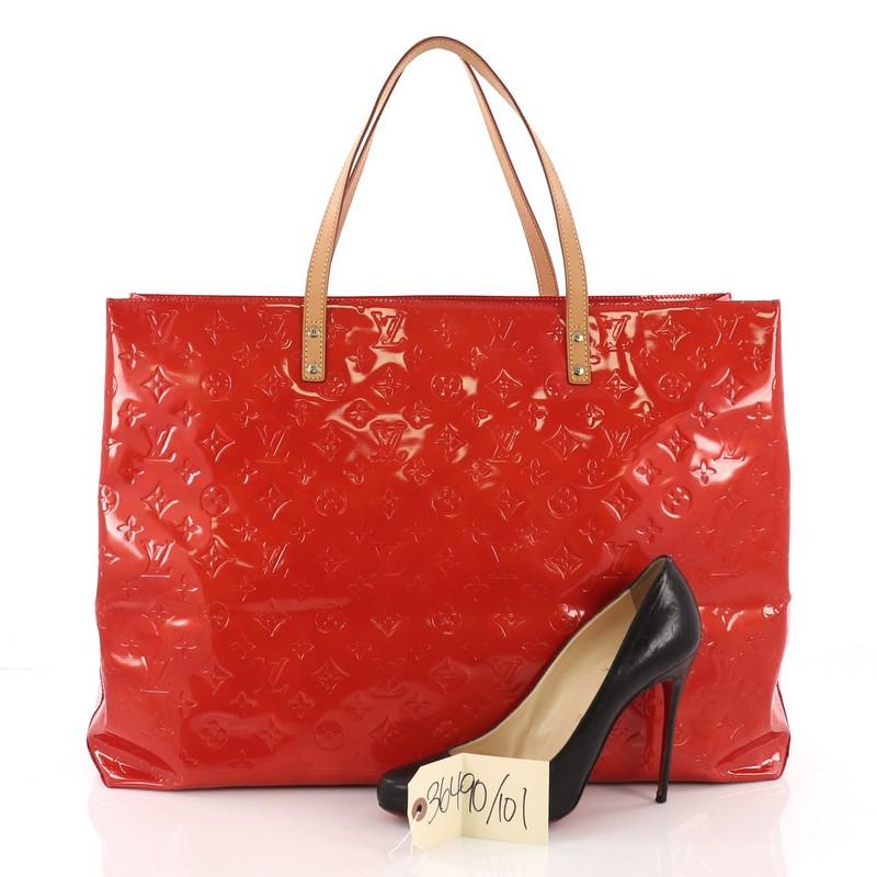 This Louis Vuitton Reade Handbag Monogram Vernis GM, crafted in red monogram embossed vernis leather, features dual vachetta leather top handles and gold-tone hardware. Its wide top opens to a red fabric interior with side zip pocket. Authenticity