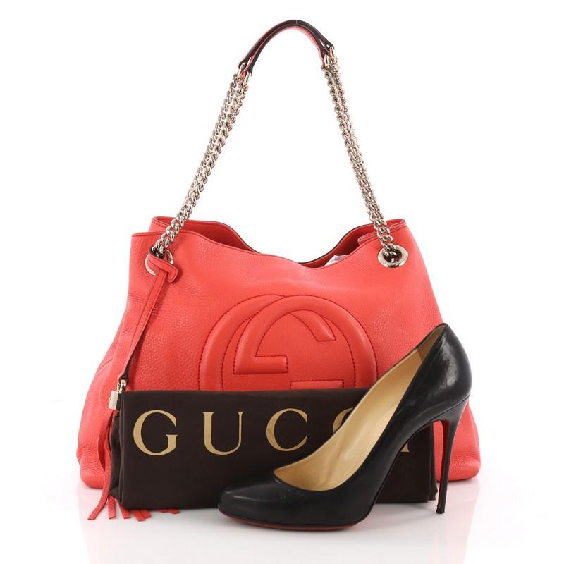 This Gucci Soho Chain Strap Shoulder Bag Leather Medium, crafted from coral leather, features gold chain strap, signature interlocking Gucci logo stitched in front, and gold-tone hardware. Its open top with hook-clasp closure opens to a beige fabric