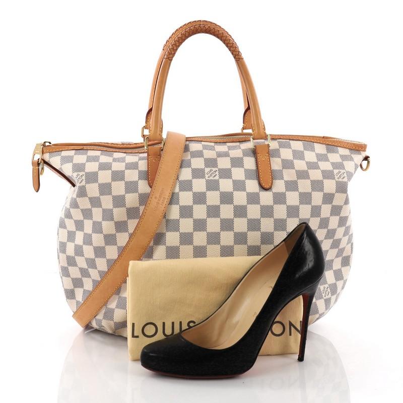 This Louis Vuitton Riviera Handbag Damier MM, crafted in damier azur coated canvas, features dual braided handles, vachetta leather trims and piping and gold-tone hardware. Its zip closure opens to a beige fabric interior with slip pockets.