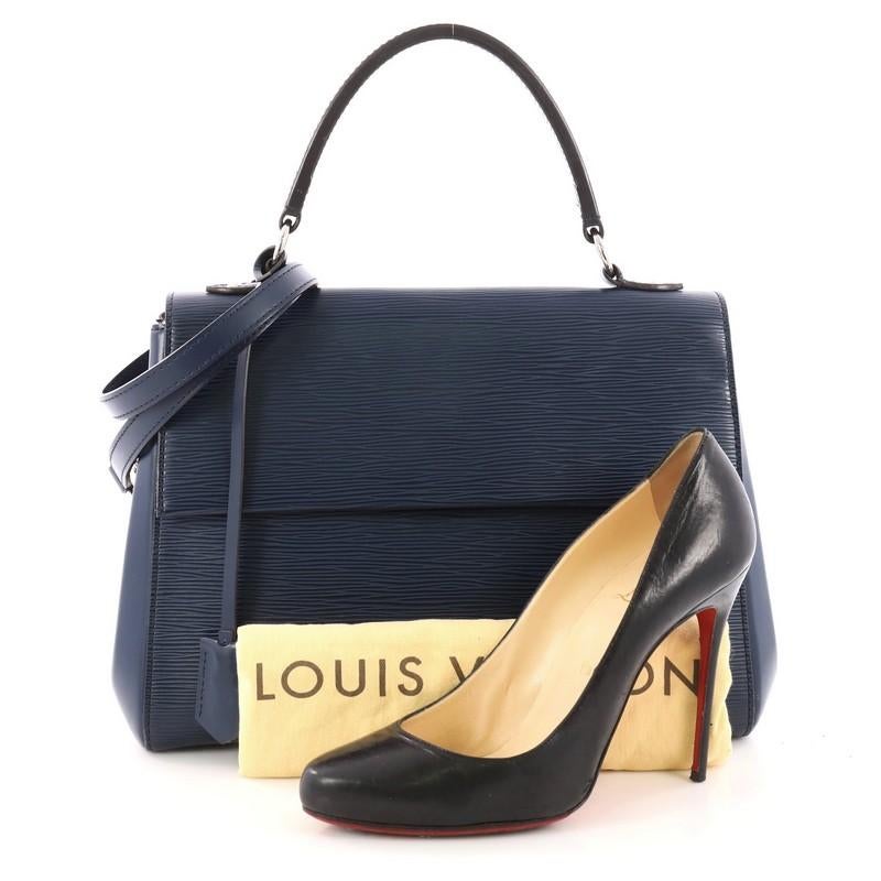 This authentic Louis Vuitton Cluny Top Handle Bag Epi Leather MM is a chic and sophisticated everyday bag. Crafted from blue epi leather with smooth leather panels, this timeless bag features short flat top handle, detachable strap, side snap