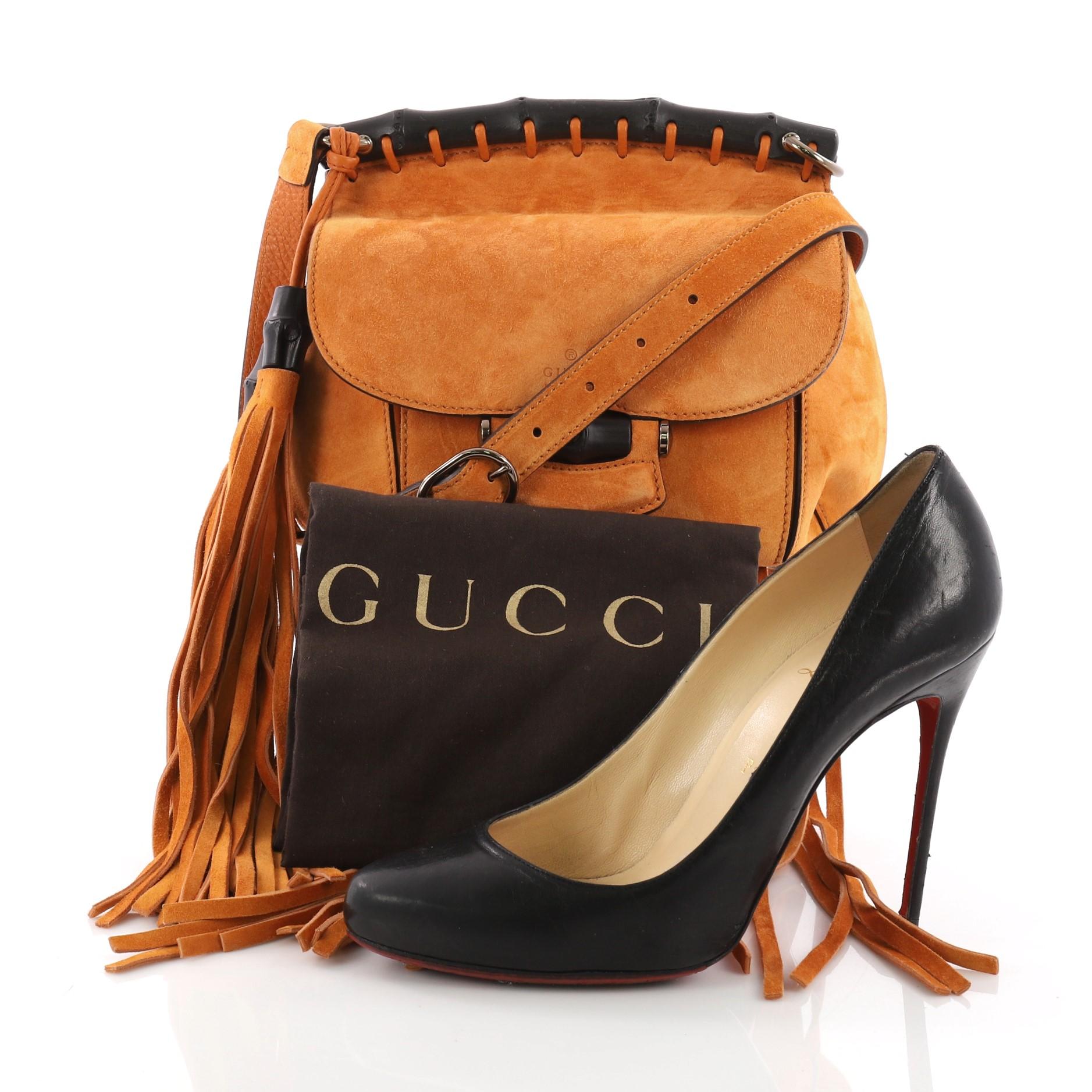 This Gucci Nouveau Fringe Crossbody Bag Suede Small, crafted in orange suede, features adjustable shoulder strap, cascading fringes at its base, and bronze and gold-tone hardware accents. Its bamboo closure opens to a nude leather interior with