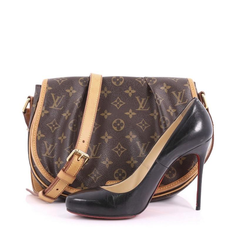 This Louis Vuitton Menilmontant Handbag Monogram Canvas PM, crafted in brown monogram coated canvas, features a full frontal flap with pleated design, flat leather adjustable shoulder strap and gold-tone hardware. Its hidden magnetic snap closure