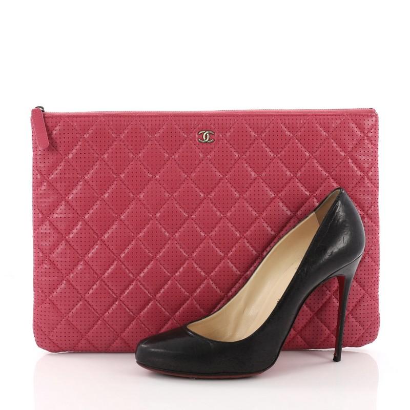 This Chanel O Case Clutch Quilted Lambskin Large, crafted from pink quilted perforated lambskin, features a tiny CC logo on the front and aged silver-tone hardware. Its zip closure opens to a pink nylon interior. Hologram sticker reads: 20549647.