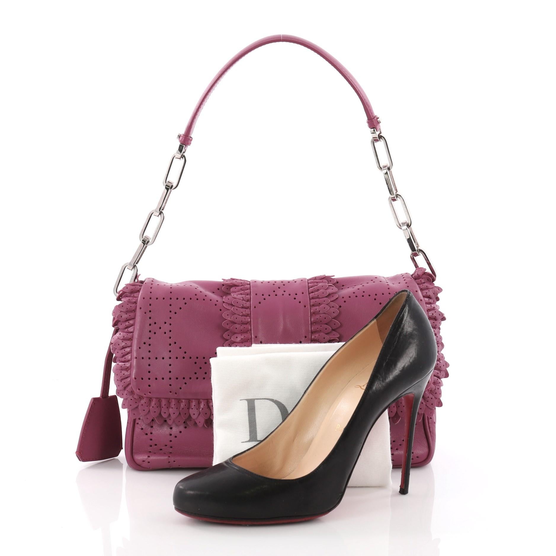 This Christian Dior New Lock Ruffle Flap Bag Perforated Leather Small, crafted in fuchsia cannage stitched perforated leather, features a single loop leather shoulder strap, ruffled trim edges and silver-tone hardware. Its logo engraved push-lock