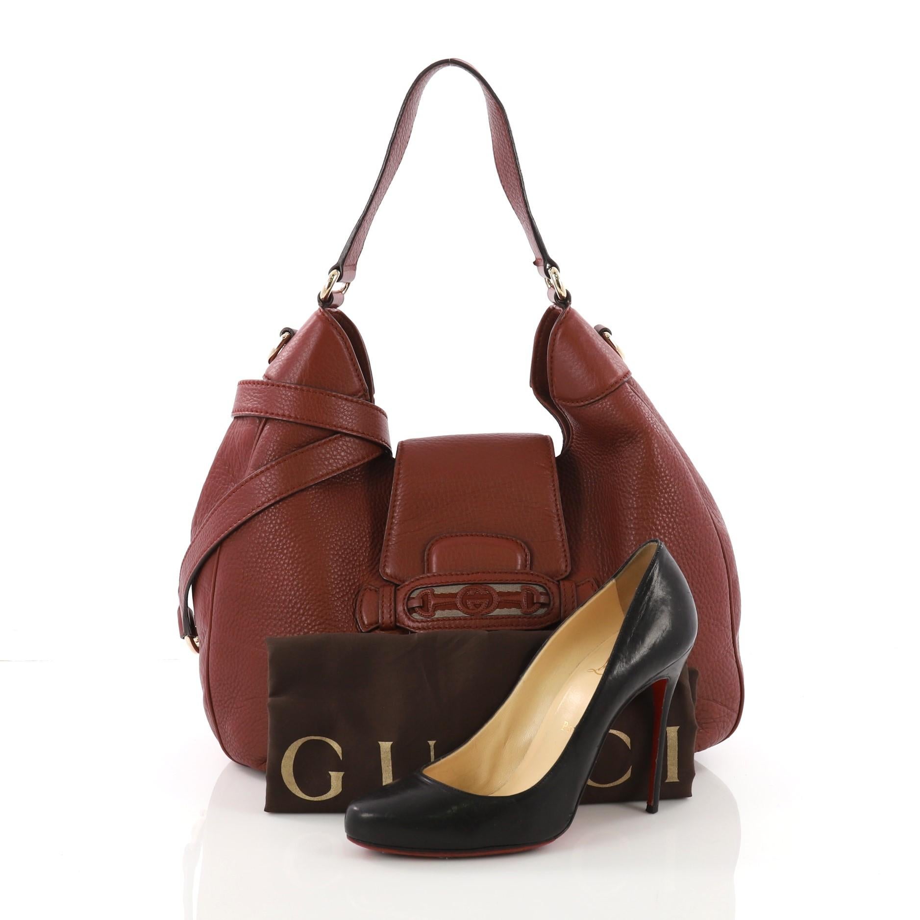 This Gucci Dressage Hobo Leather, crafted from brown leather, features single loop leather handle, belt strap closure with Gucci web logo and gold-tone hardware. It opens to a beige fabric interior with side zip and slip pockets. **Note: Shoe