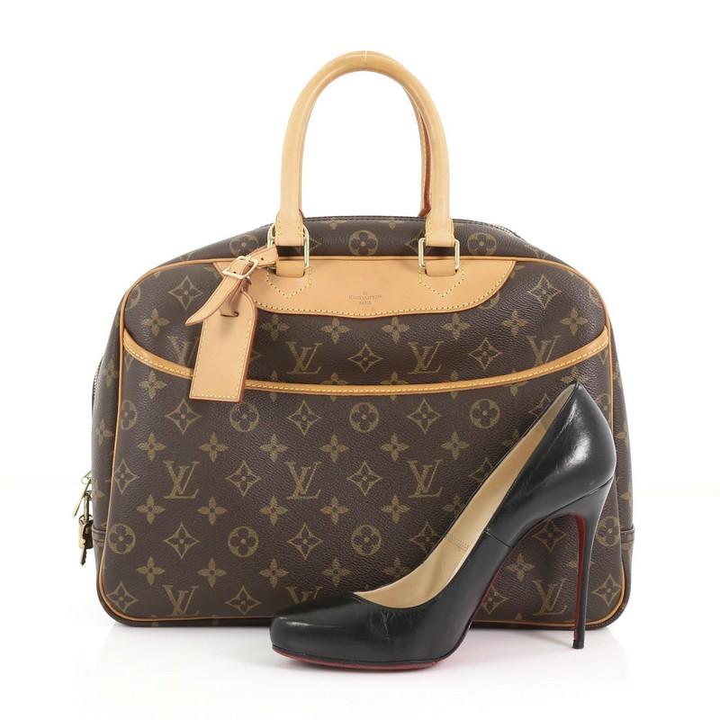 This Louis Vuitton Deauville Handbag Monogram Canvas, crafted from brown monogram coated canvas, features dual rolled vachetta leather handles and trims, exterior front slip pocket, and gold-tone hardware. Its top zipped closure opens to a beige