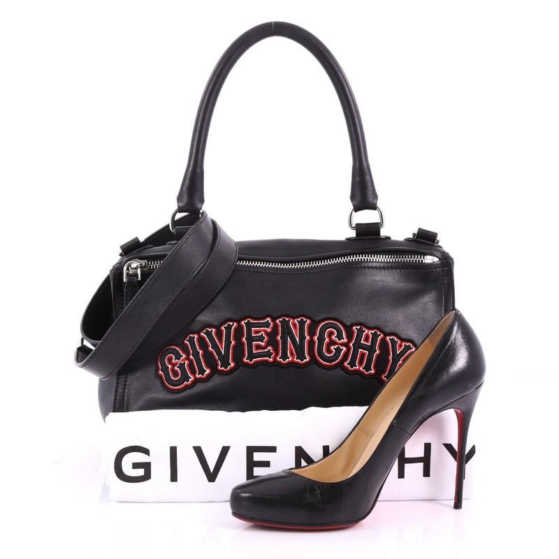 This Givenchy Pandora Bag Patchwork Leather Medium, crafted from black leather, features a pandora box-inspired silhouette, red embroidered logo, a singular top handle, and silver-tone hardware. Its two-way zip fastenings open to a black fabric