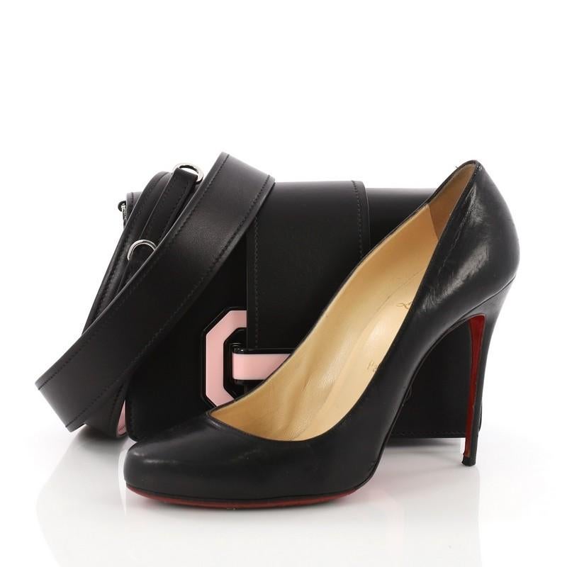 This Prada Plex Ribbon Shoulder Bag City Calfskin Small, crafted from black calfskin leather, features removable shoulder strap, flap top with geometric pink plexi tab closure and silver-tone hardware. Its tab closure opens to a black fabric