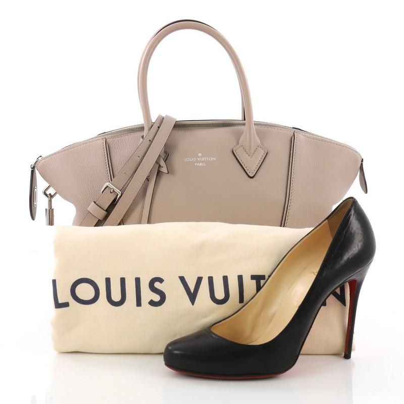 This Louis Vuitton Soft Lockit Handbag Leather PM, crafted from taupe leather, features dual rolled handles, curved top, LV padlock on its side, and silver-tone hardware. Its top zip closure opens to a beige suede interior with side zip and slip