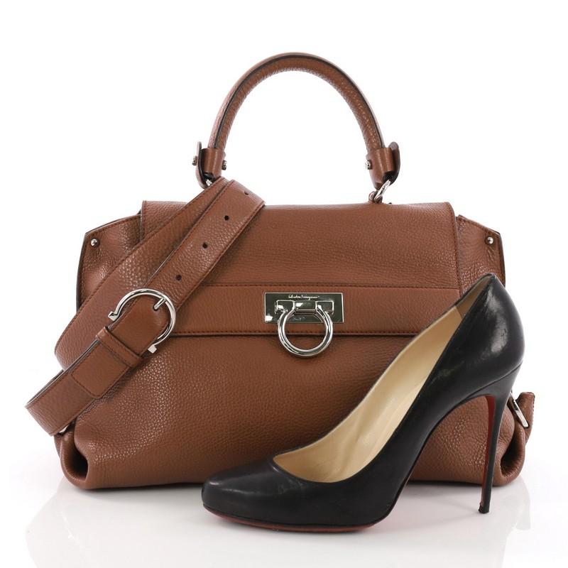 This Salvatore Ferragamo Sofia Satchel Pebbled Leather Medium, crafted from brown pebbled leather, features a sturdy top handle, zipped exterior back pocket, side gancini detailing and polished silver hardware. The brand's signature flip-lock Gancio