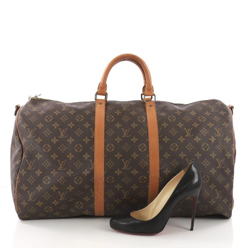 This Louis Vuitton Keepall Bandouliere Bag Monogram Canvas 55, crafted in brown monogram coated canvas, features dual rolled handles, natural cowhide leather trims and gold-tone hardware. Its top zip closure opens to a brown fabric interior.