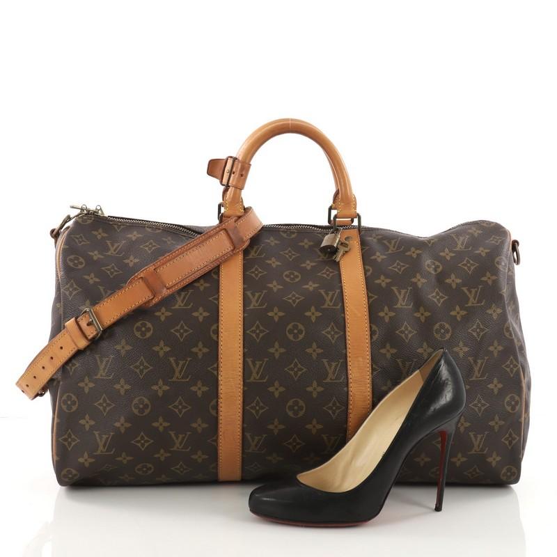 This Louis Vuitton Keepall Bandouliere Bag Monogram Canvas 50, crafted in brown monogram coated canvas, features dual rolled leather handles, natural cowhide leather trims and gold-tone hardware. Its zip closure opens to a roomy brown fabric