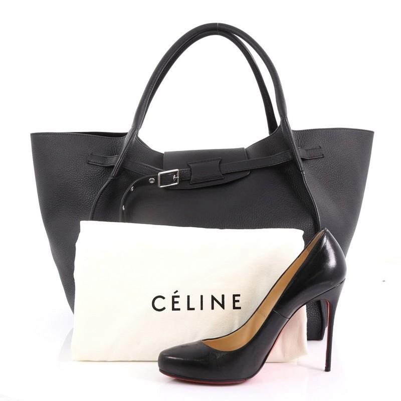 This Celine Big Bag Grained Calfskin Medium, crafted in black grained calfskin leather, features dual rolled handles, belt detail on the front and silver-tone hardware. It opens to a black suede interior with zip pocket. **Note: Shoe photographed is