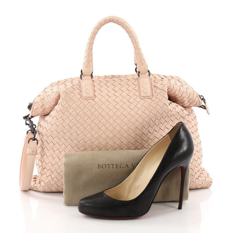This Bottega Veneta Convertible Satchel Intrecciato Nappa Medium, crafted in light pink nappa leather in intrecciato woven method, features dual rolled leather handles, and matte gunmetal-tone hardware. Its zip closure opens to a taupe suede