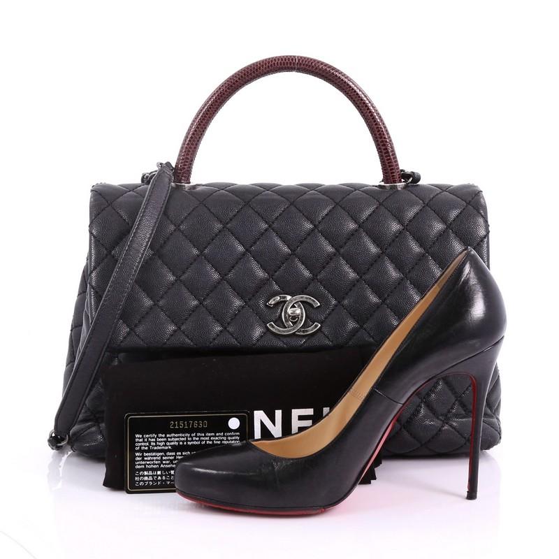 This Chanel Coco Top Handle Bag Quilted Caviar with Lizard Medium, crafted in black quilted caviar, features a single loop genuine lizard handle, woven-in leather chain strap, exterior back pocket and aged silver-tone hardware. Its CC turn-lock