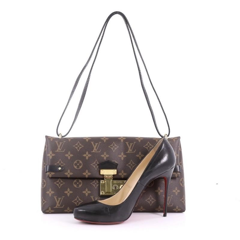 This Louis Vuitton Sac Triangle Handbag Monogram Canvas PM, crafted in brown monogram coated canvas, features a leather shoulder strap and gold-tone hardware. Its front flap with press-lock closure opens to a black microfiber interior with slip
